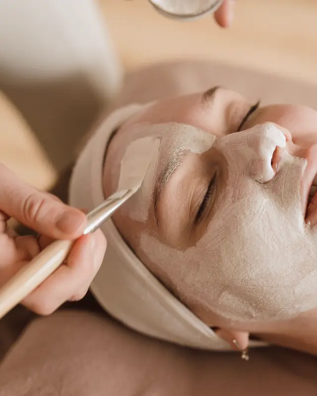 Application d'un masque au pinceau sur le visage.